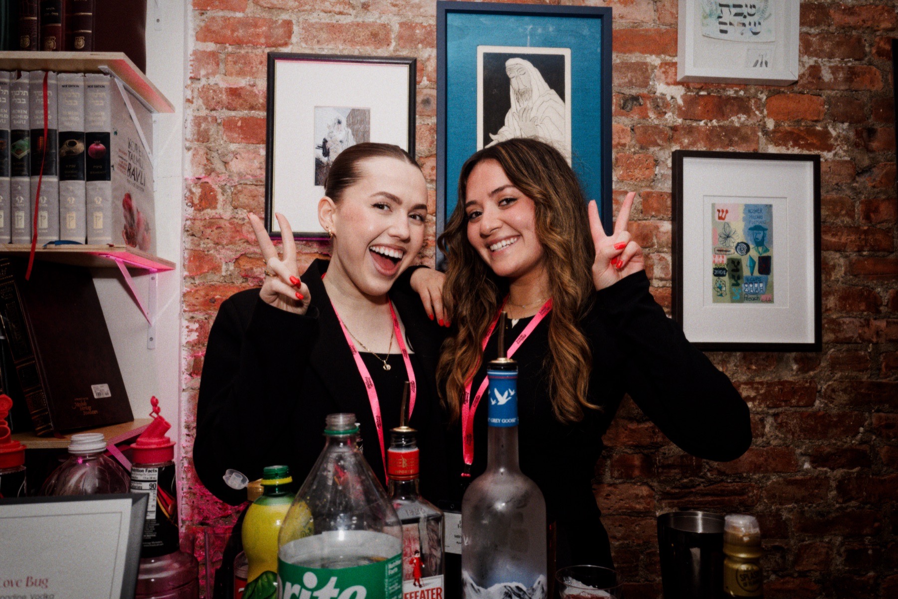 Two women smiling behind the event bar